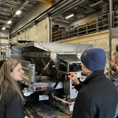 Group of people examining industrial equipment in a warehouse.