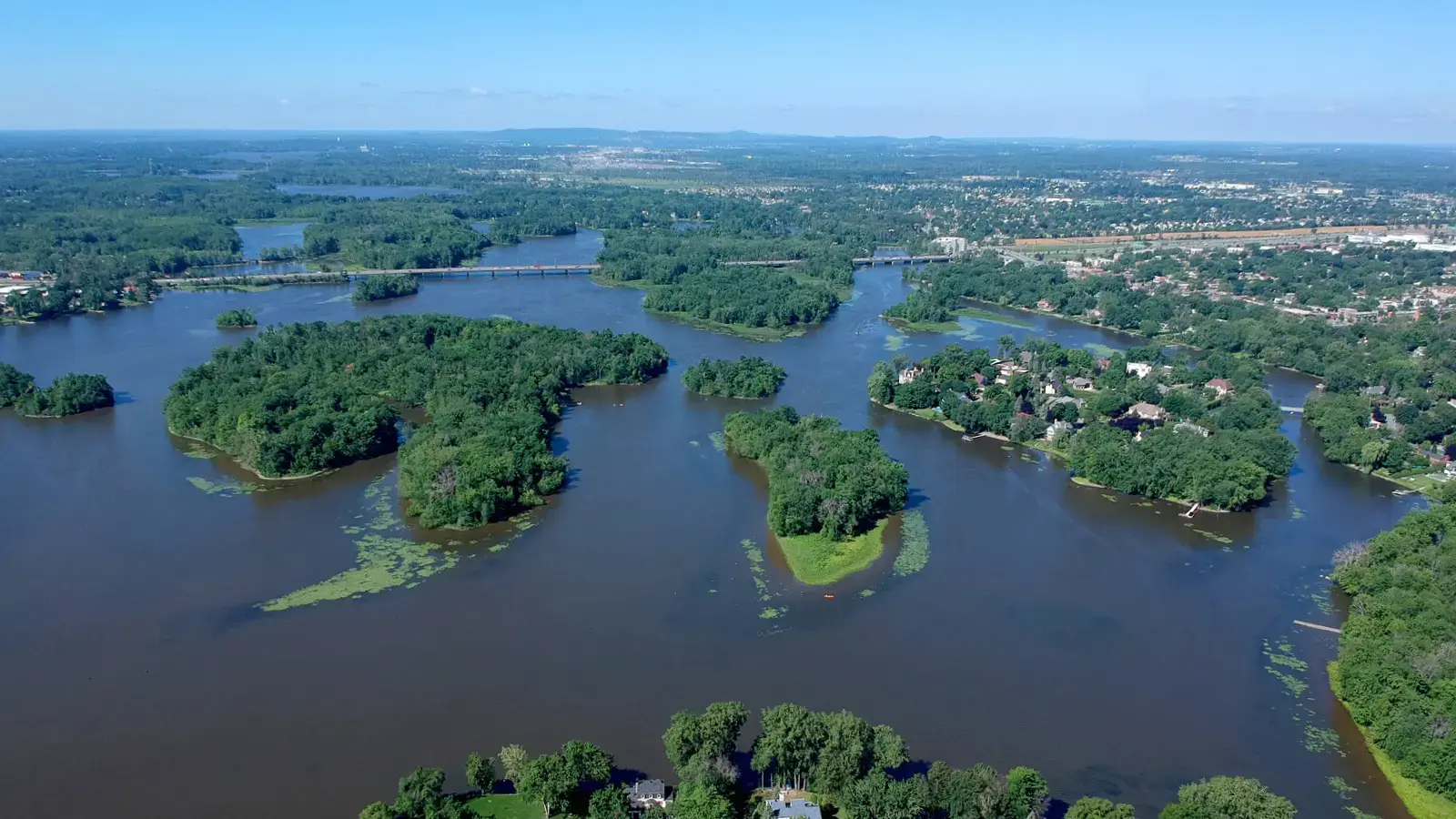 Aerial view of the Thousand Islands River, weaving through lush landscapes and vibrant communities.